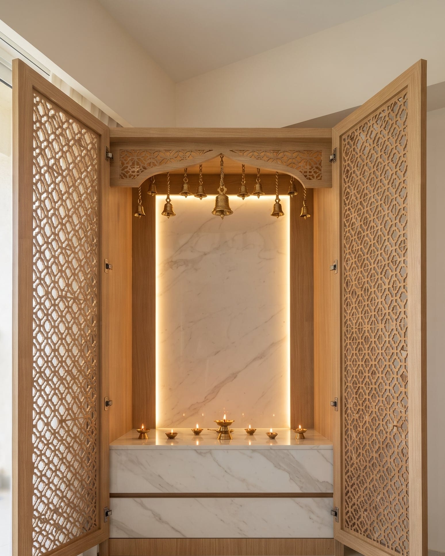 A pooja and storage unit in blue-grey with a gold-framed deity panel and a mirror